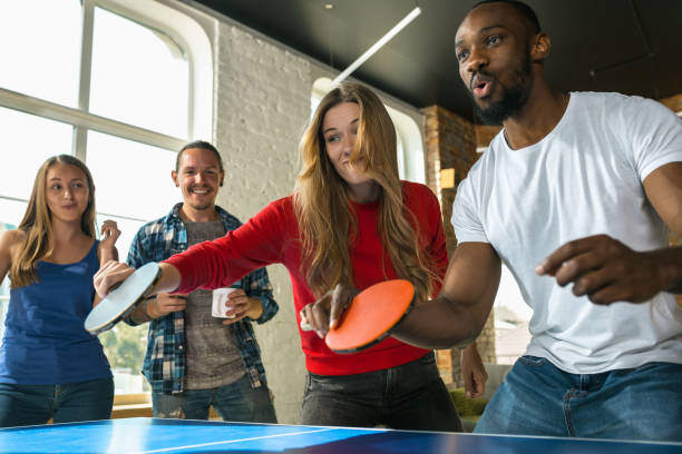 istock Young people playing table tennis in workplace, having fun 1183383686
