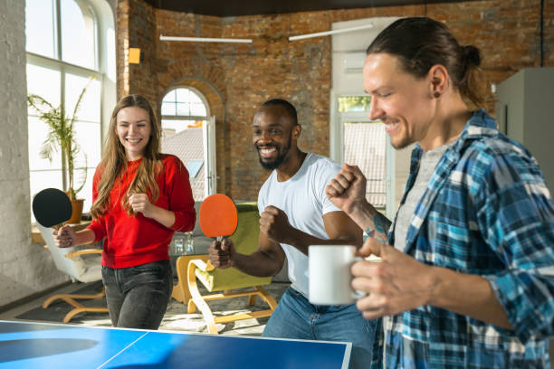 istock Young people playing table tennis in workplace, having fun 1183383722