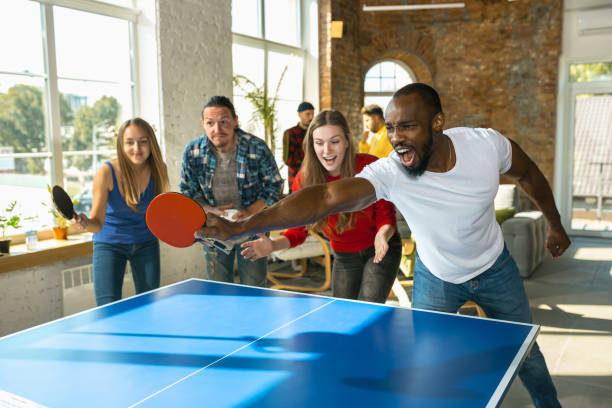istock Young people playing table tennis in workplace, having fun 1183383734