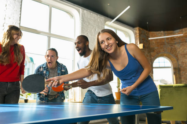 istock Young people playing table tennis in workplace, having fun 1183383740