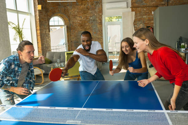 istock Young people playing table tennis in workplace, having fun 1183384408