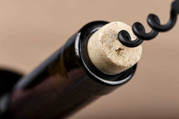 istock bottle of wine with a corkscrew in a cork, closeup. 1183384439