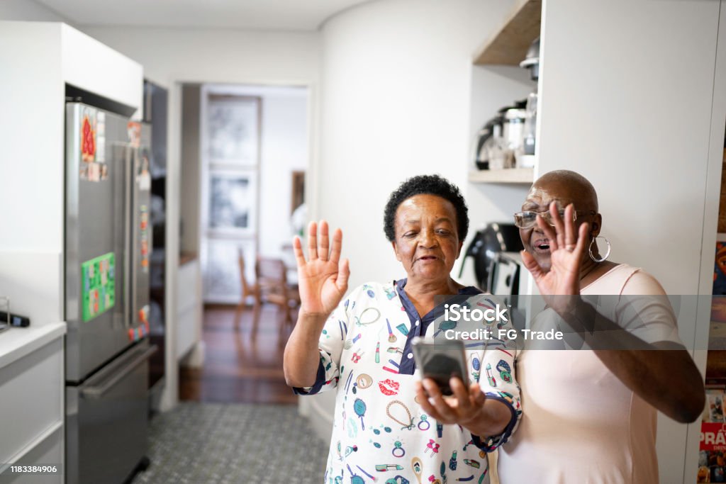 Mujeres mayores haciendo una videollamada usando teléfono inteligente - Foto de stock de Familia libre de derechos
