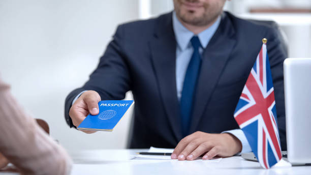 British embassy officer giving passport to immigrant, student visa approval British embassy officer giving passport to immigrant, student visa approval consul photos stock pictures, royalty-free photos & images