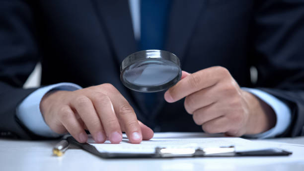 istock Attorney reading document with magnifier, studying case in detail, investigation 1183386134
