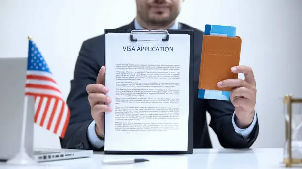 US consular officer showing visa application and passport, legal immigration