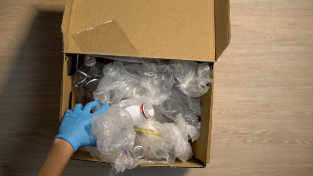 istock Drop-off station worker in gloves checking plastic trash in box, reduce waste 1183387388