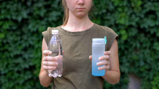 istock Lady choosing between reusable plastic bottle and ordinary, preventing pollution 1183387474