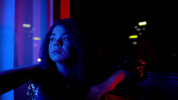 Depressed woman thinking about life problems at open terrace, evening party