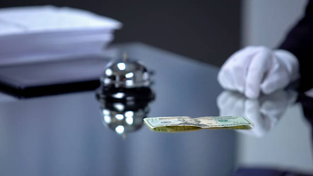 istock Dollar banknote lying front hotel receptionist, bribe for revealing secrets 1183388505