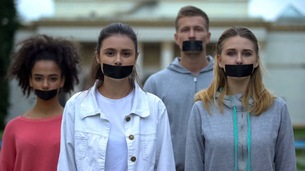 crowd performance with taped mouth, violation of speech freedom, censorship - protest political rally crowd politics imagens e fotografias de stock