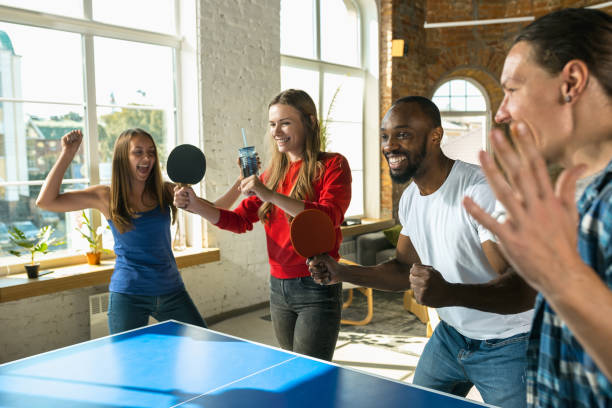istock Young people playing table tennis in workplace, having fun 1183394153