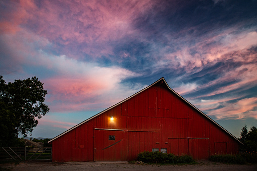 Historic Redwood red barn in the evening with dramatic sky at sunset / dusk / dawn