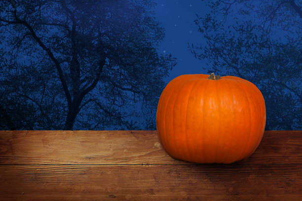 istock Halloween banner with pumpkin on wood, blue night 1183402082