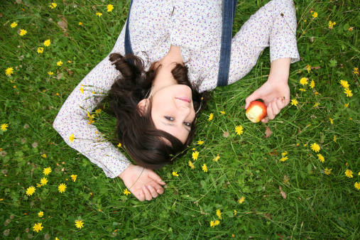 Girl Lying Down in Meadow Eating an Apple