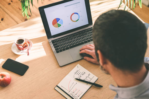 istock man checking business stats at laptop 1183405845