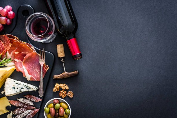 前菜フレーム:赤ワイン、イベリコハム、素朴なテーブルの上のチーズ - スペイン文化 写真 ストックフォトと画像