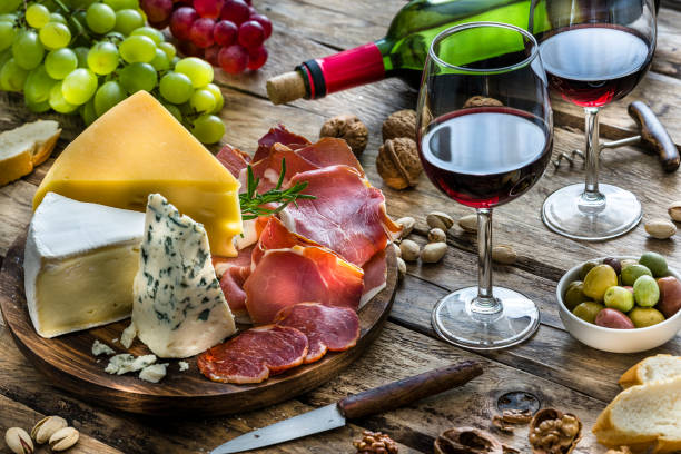 istock Appetizer: red wine, cheese and cured ham on rustic wooden table 1183406638