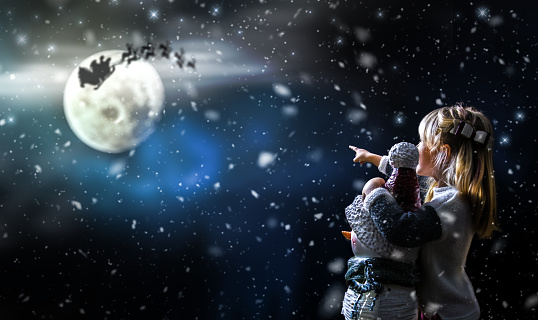 Girl Holding a Snowman and Pointing to Santa Claus Sleigh in the Sky