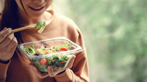 closeup woman eating healthy food salad - box lunch fotos imagens e fotografias de stock