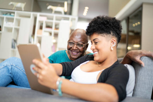 istock Grandmother and granddaughter using digital tablet in the couch 1183408295