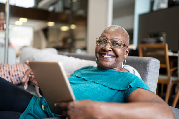 ritratto di donna anziana che usa il tablet a casa - senior adult 70s female women foto e immagini stock