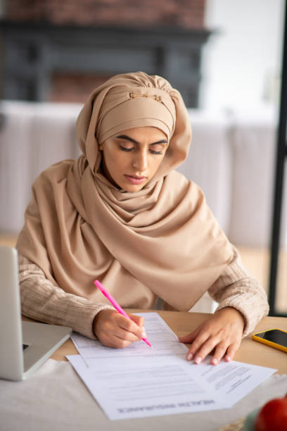 istock Pretty woman wearing hijab caring out duties 1183408567
