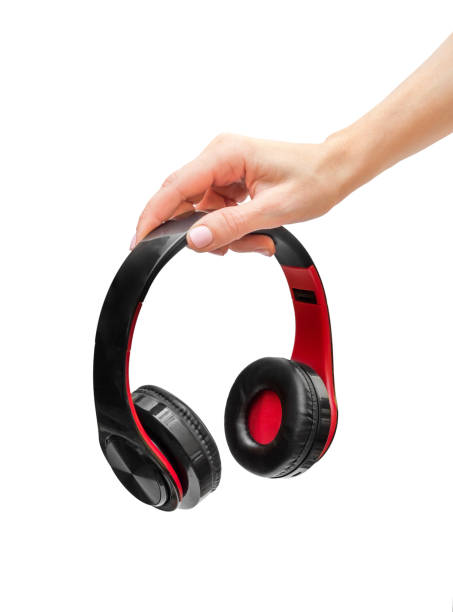 istock Woman's hand holding headphones. Isolated on white. 1183412364