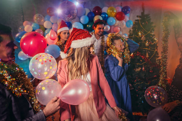 Group of young women and men having fun with balloons at a New Years party