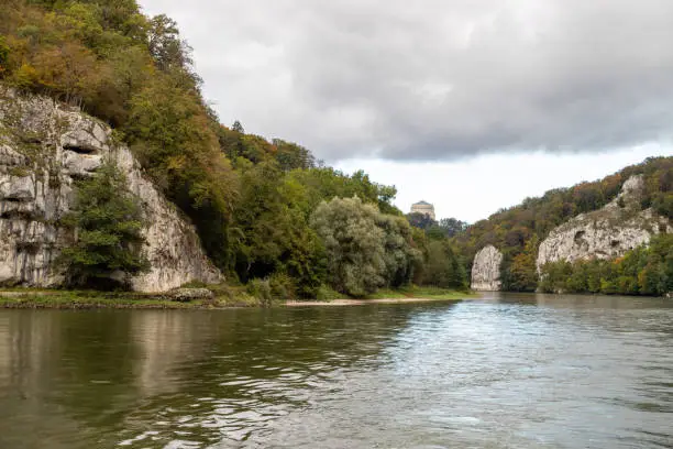 Nature reserve at Danube river breakthrough near Kelheim, Bavaria, Germany in autumn with limestone rock formations and Befreiungshalle on the Michelsberg in the background