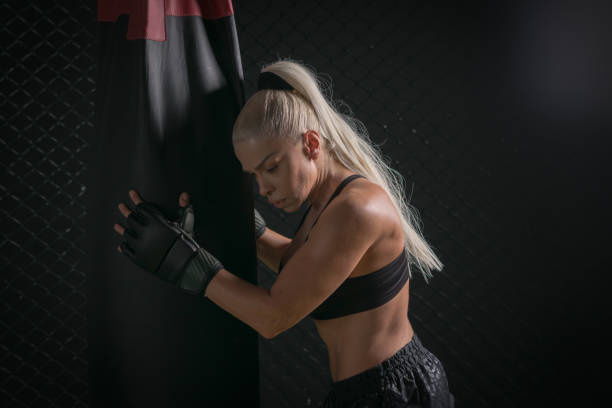 istock Woman Boxer In Gloves Training on a black background 1183413918