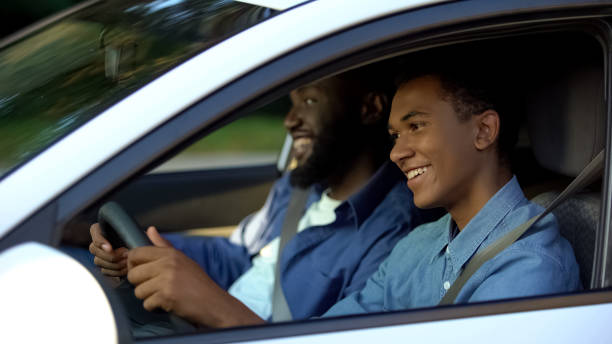 istock Male examiner pleased with young male passing driving test, support and help 1183419548