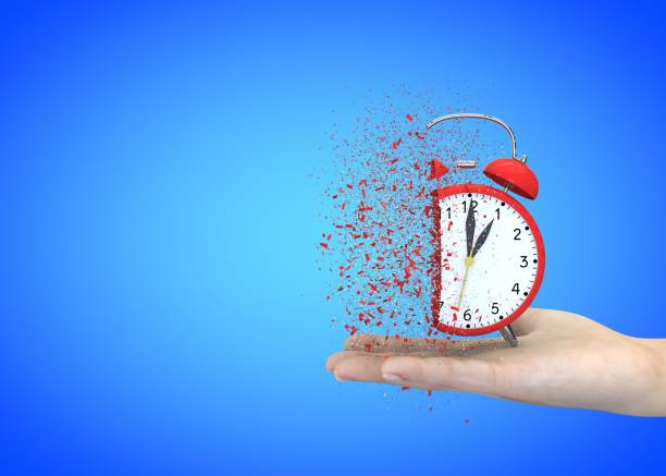 istock Alarm clock red on a blue background explodes in the girl's hands 1183423943