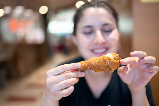 giovane donna con pollo fritto - deep fried people fried chicken foto e immagini stock