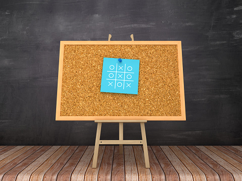 Easel with TI TAE TOE Sticky Note on Corkboard Frame - Chalkboard Background  - 3D Rendering