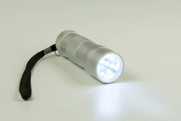 istock pocket metal flashlight with burning LEDs on a white background 1183426038
