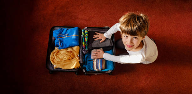 istock The child prepares the suitcase 1183427300