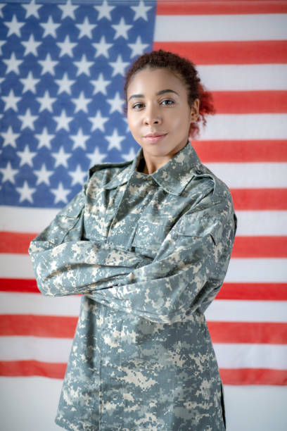 istock Serious young pretty servicewoman wearing camouflage uniform 1183430212