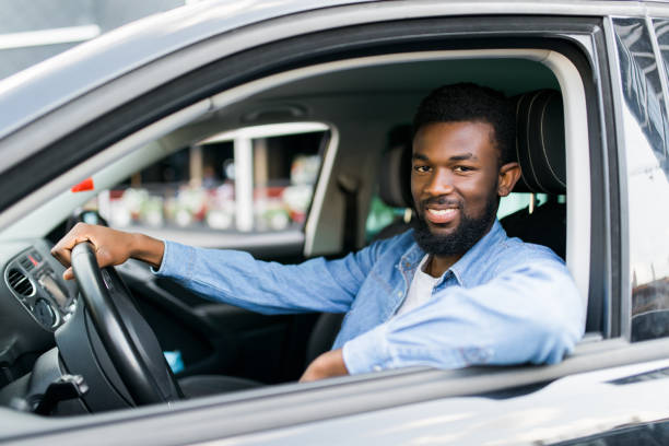 istock Young affluent successful african man driving his new expensive car 1183438557