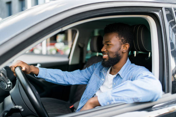 istock Young affluent successful african man driving his new expensive car 1183438572