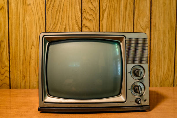 Small Retro Televison with Vintage Knobs in Front of a Wood Paneled Wall This is a photograph of a small retro television from the 1980s in front of a vintage wood paneled wall. old television stock pictures, royalty-free photos & images