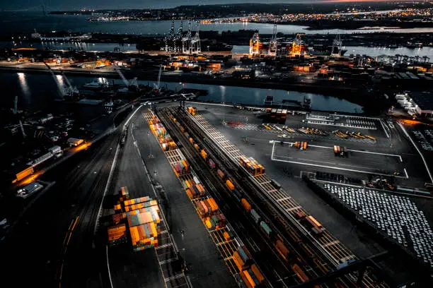 Photo of Aerial view of the New Jersey Shipyard with numerous cranes, gantries and shipping containers, captured at golden hour