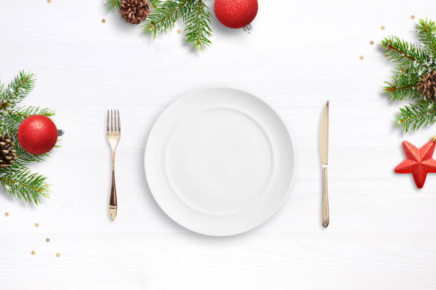 istock Empty plate, fork and knife surrouded by Christmas decorations. Top view, flat lay. Christmas dinner concept. 1183442625