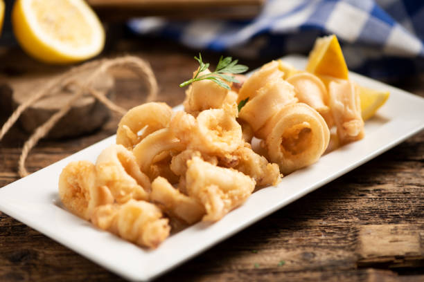 Traditional Italian fried calamari and lemon slice stock photo