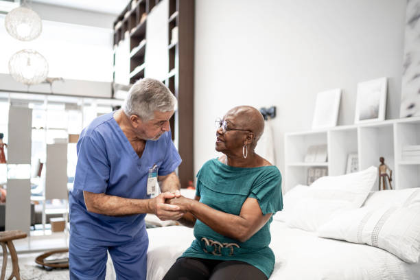 doctor consolando a un paciente, cogido de la mano - patient room fotografías e imágenes de stock