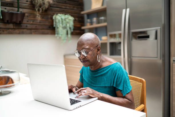 istock Senior woman using laptop at home 1183448126