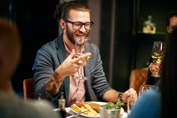 istock Man drinking wine at restaurant with friends. 1183448205