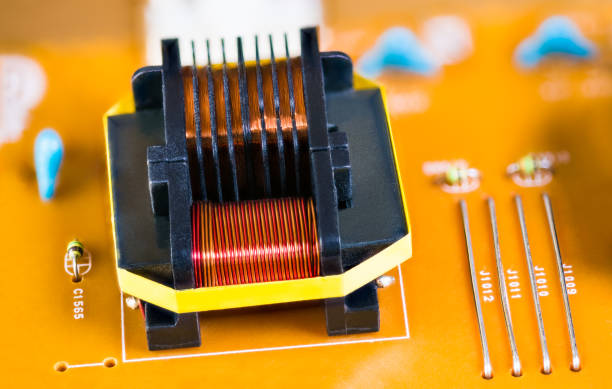 istock Magnetic ferrite core inductor on beige printed circuit board. Induction coil detail. Electrotechnology 1183448341