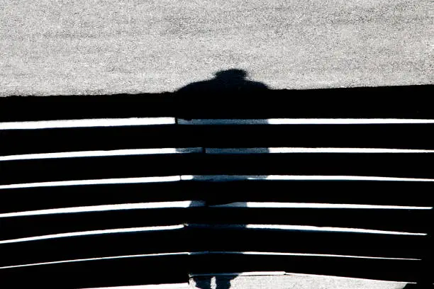 Photo of Abstract blurry shadow silhouette of a man on asphalt stairs