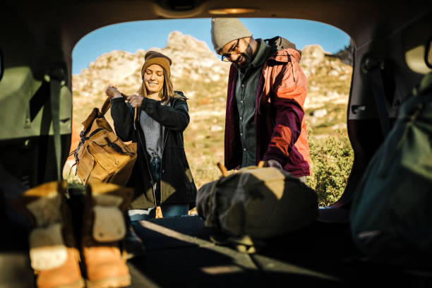 istock Couple taking backpack out of car trunk in nature 1183453489